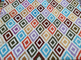 A multicolored geometric-patterned kilim rug with a wool base and hand-spun wool pile.