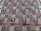 A close-up view of a traditional Persian Birjand rug with a geometric pattern featuring a mix of colors including red, blue, green, and beige.