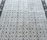 Close-up of a traditional Indian Jaipur rug with a geometric herati design in beige and black tones.