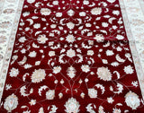 An ornate Oriental Jaipur rug with a floral design in beige, gold, maroon, pink, and pistachio tones, featuring intricate patterns and a cotton base.