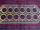 A rectangular, traditional, hand-knotted wool rug with a geometric pattern featuring a camel foot design in beige, maroon, and black tones.