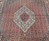 A certified hand knotted Persian Bijar rug with an intricate central medallion Herati design in a pinkish red to blue tone, featuring detailed patterns and a fine cotton base.