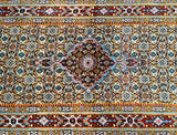 Close-up of a hand knotted Persian hall runner with a geometric and floral pattern in multiple colors including beige, gold, blue, maroon, orange, and green.