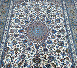 A vintage Persian Kashmar rug with a floral pattern in blue, beige, brown, green and blue tones, featuring a geometric sunflower medallion design.