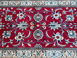A hand-knotted Persian Nain hall runner rug with a floral design in red, beige, cream, grey, brown, and blue tones on a cotton base.