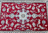 A hand-knotted Persian Nain rug with a dense pure wool pile on a cotton base, featuring an ivory beige, red, and blue tone dyed in a traditional floral design.
