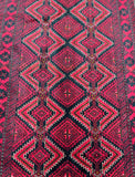A close-up of a Tribal Persian Balouchi Rug featuring a geometric diamond design in red, beige, yellow, and black tones.