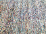 A close-up of a contemporary handmade Afghan Chobi rug with a geometric pattern of stripes in beige and brown tones.