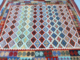 A square-shaped, hand-woven Afghan Waziri Kilim rug with a geometric tribal design featuring a variety of colors including blue, red, green, and beige.